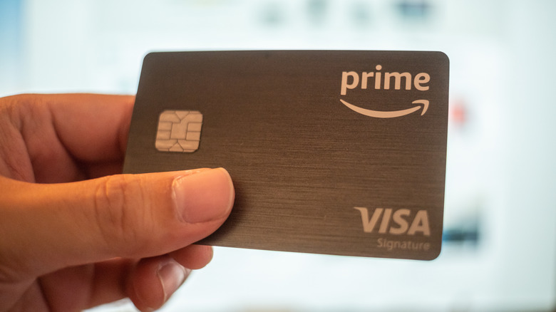 A man holding an Amazon Prime Visa Card