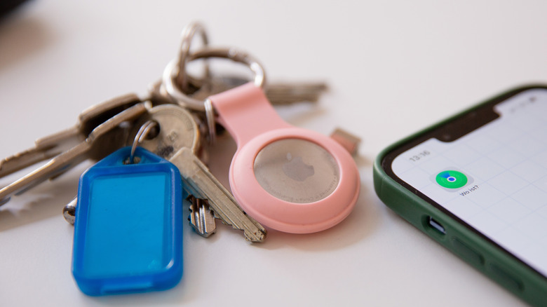 Apple AirTag attached to keys and placed next to an iPhone