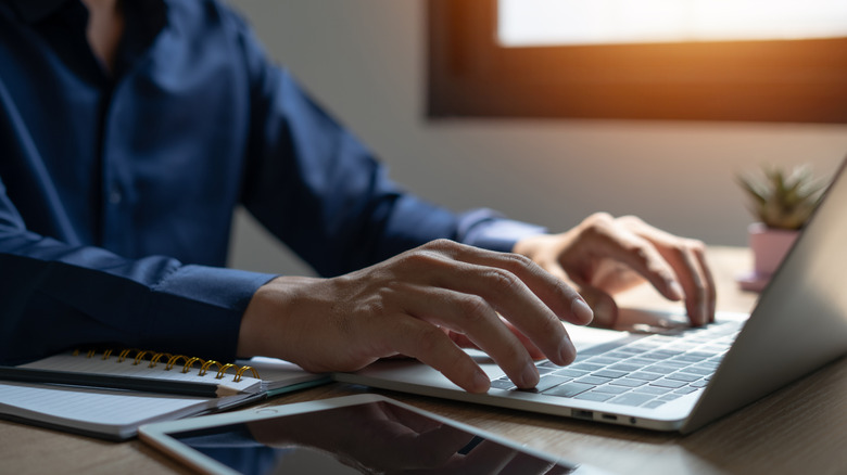 A person typing on a laptop.