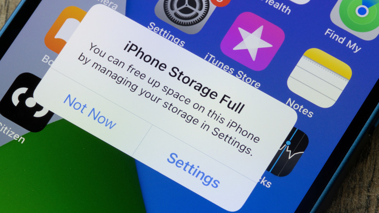 A close-up of an iPhone showing the storage full message.