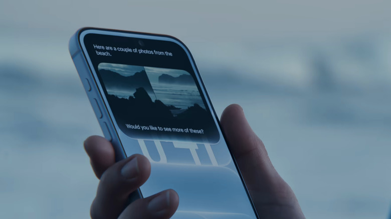 A hand holding an iPhone with Siri AI on the screen