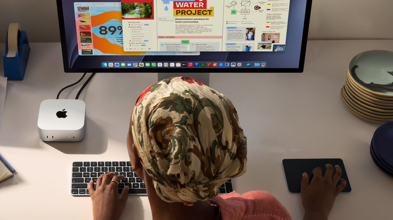 Woman using new Apple Mac Mini 2026 model on monitor
