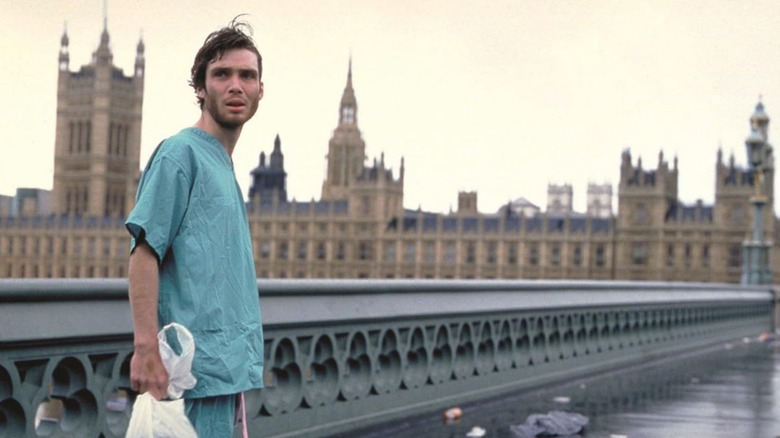 Cillian Murphy as Jim standing on the bridge with London in the background