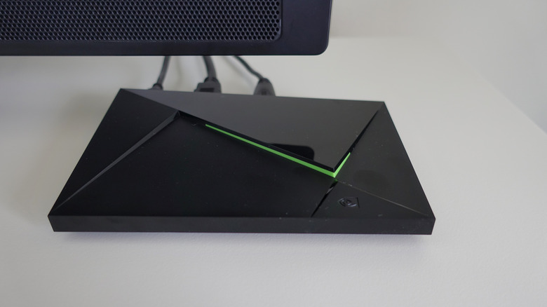 nvidia shield TV box sitting on entertainment center beneath TV