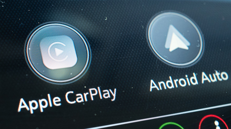 Close-up of Apple CarPlay and Android Auto logos on the dashboard of a vehicle