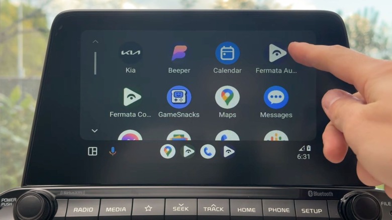 person pointing to Fermata Auto icon on dashboard