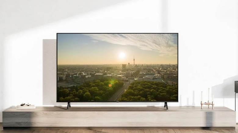 The 65-inch model of the Panasonic W95A TV on TV stand in a living room