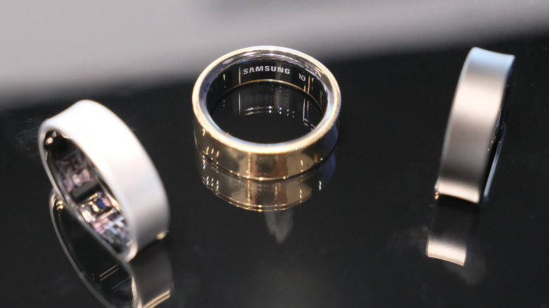 Three silver Samsung Galaxy Rings on a glass surface