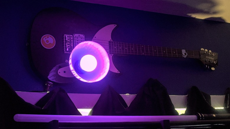 Smart bulb with purple hue powered on and installed in guitar fixture.