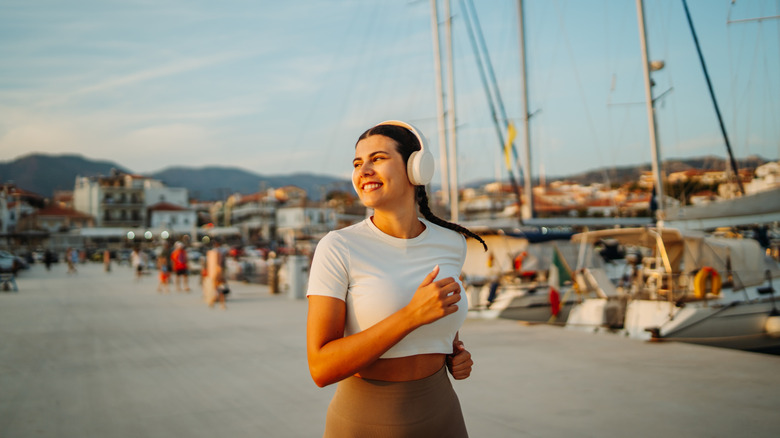 A woman listening to headphones while running