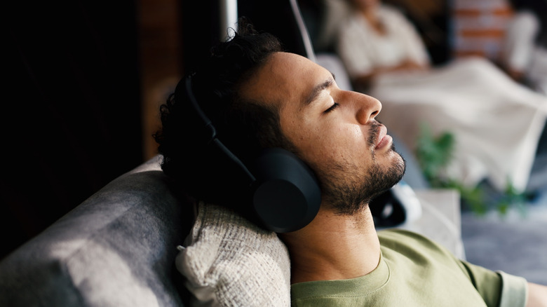 A man lounging and listening to headphones