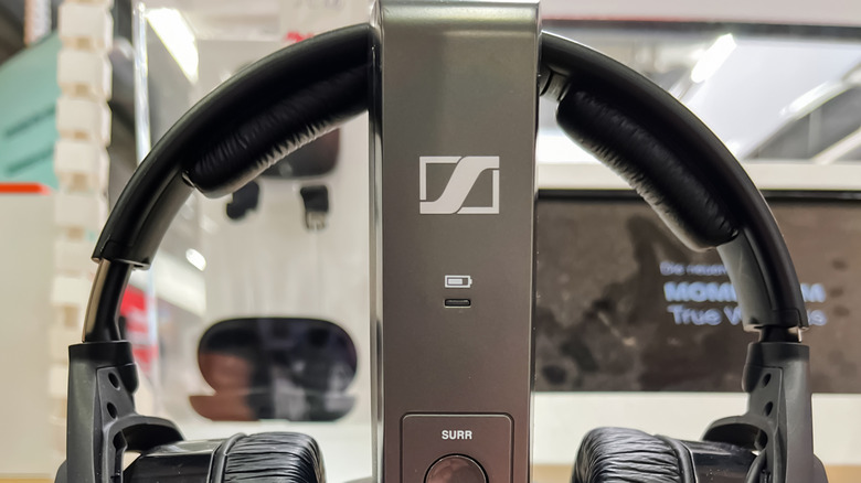 A pair of Sennheiser headphones on a charging stand with a battery symbol
