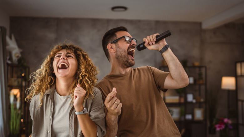 Couple singing during at-home karaoke party