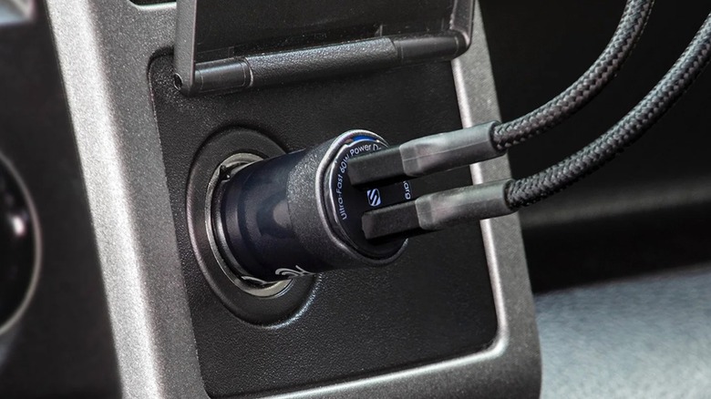 Two USB cords plugged into a Scosche PowerVolt car charger.