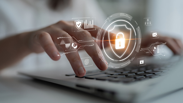 A person typing with a security-related graphic over the keyboard