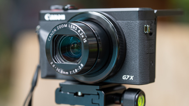 The Canon PowerShot G7 X Mark III seen mounted to a tripod outdoors.