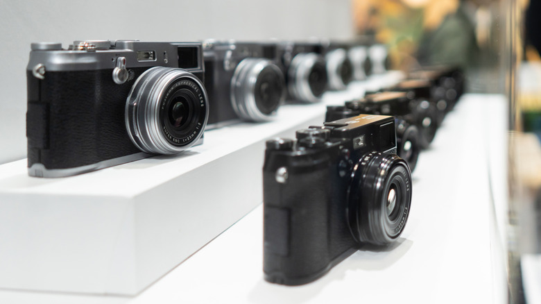 A visitor takes a photograph of X100VI mirrorless digital cameras displayed in the Fujifilm booth during the CP+ (CP Plus) 2024 show on February 22, in Yokohama, Japan.
