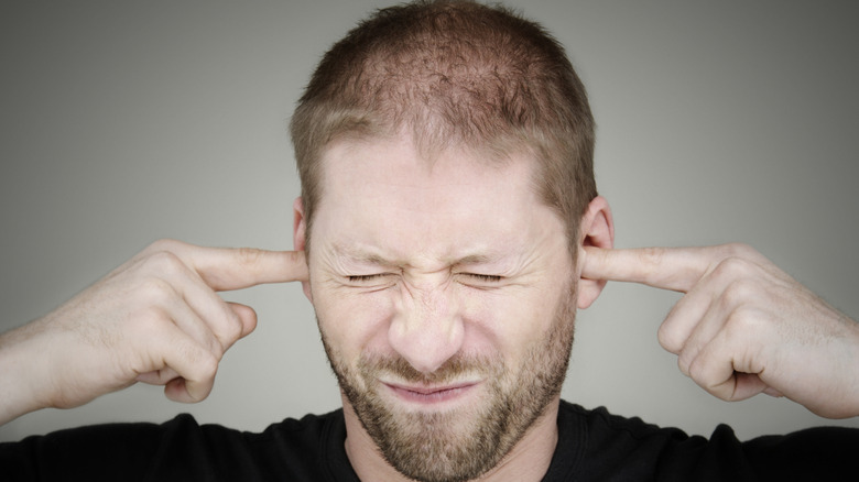 A person visibly irritated by noise