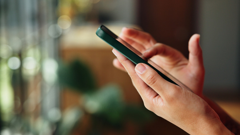 Close-up of hand holding smartphone at angle