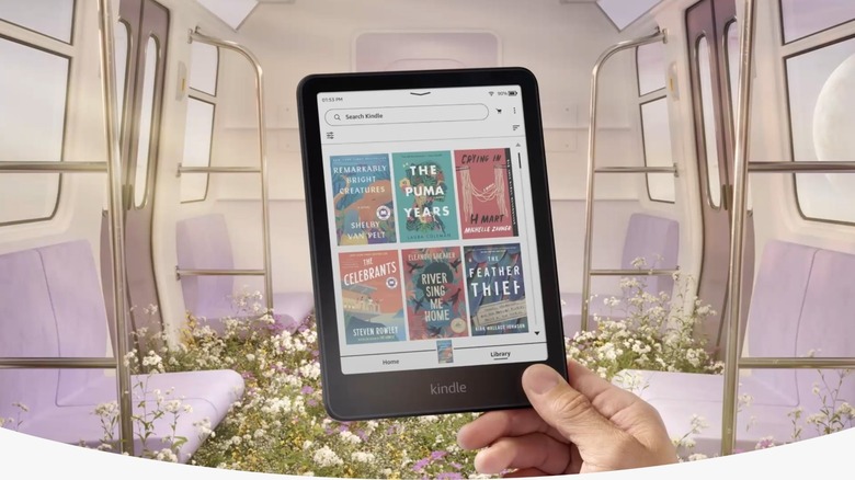 Hand holding Kindle Colosoft showing colored book covers in the library