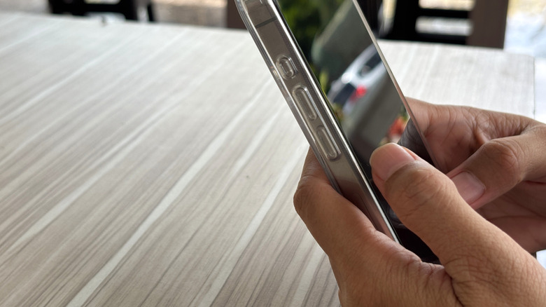Close-up of hands using phone with screen protector