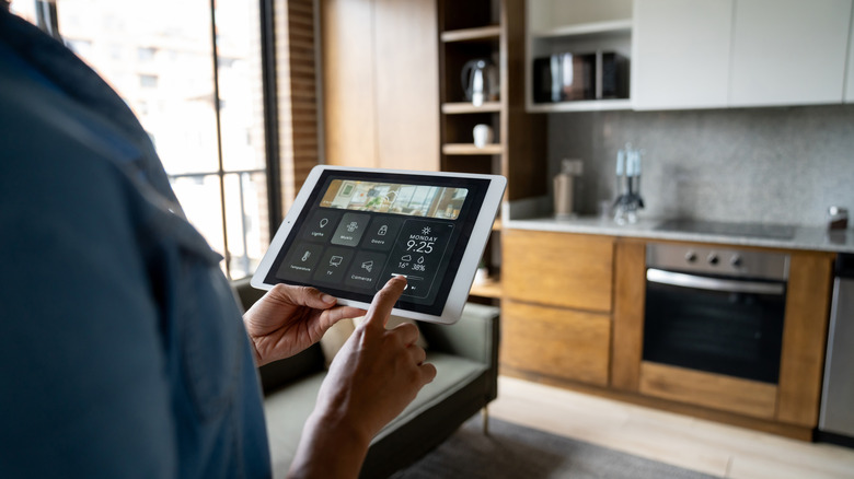 Close-up on a person controlling the temperature of their smart home using an app on a tablet