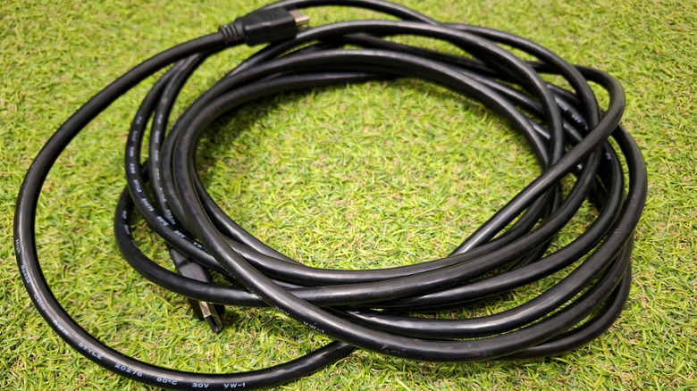 HDMI cable coiled and set down on vivid green fake grass
