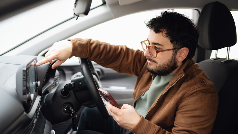 A person adjusting Android Auto settings in a car