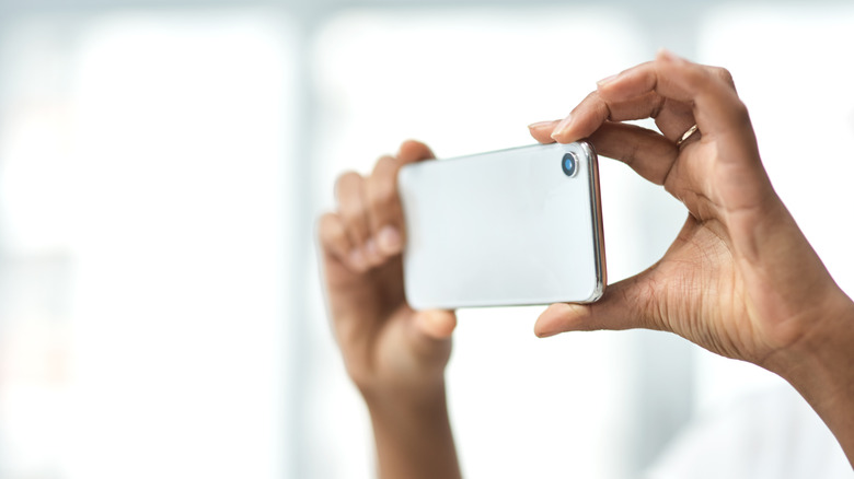 Close-up of hands taking picture a with a phone