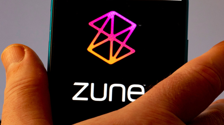 Close-up of hand holding device with Zune logo on screen