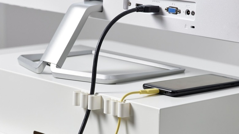 Kalkstuff Cable Holder holding an HDMI cable on the back of a table