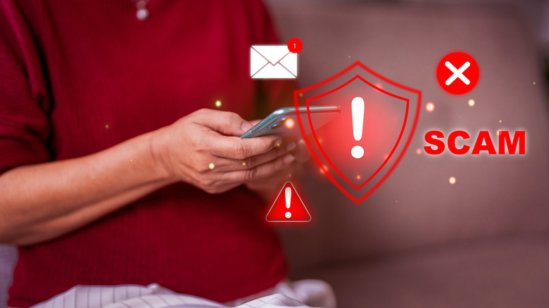 Person holding phone with graphic indicating scams, viruses, and threats