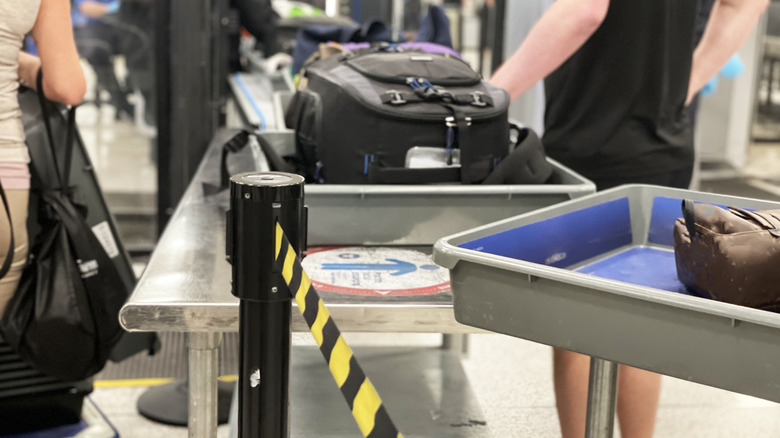 People in line for a baggage screening at an airport.