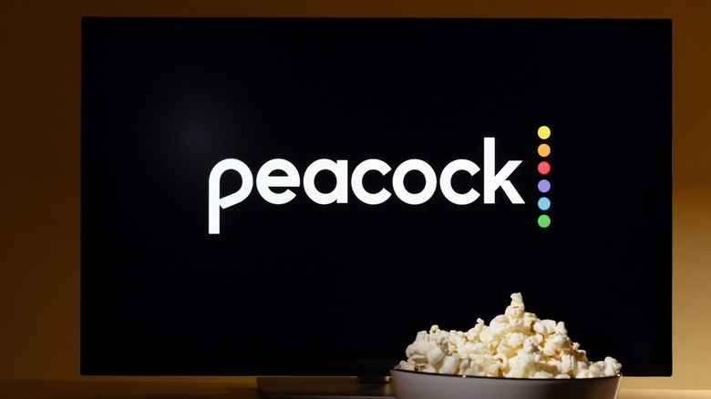 A monitor with Peacock logo on the screen and popcorn in a bowl on the front