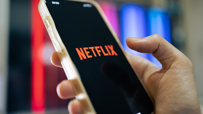 A close up of an iPhone 13 with Netflix splash screen