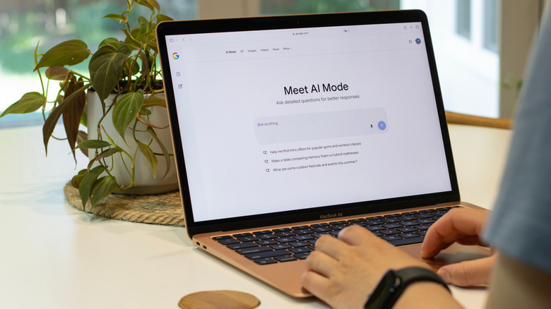 A person using Google's AI Mode on a laptop.