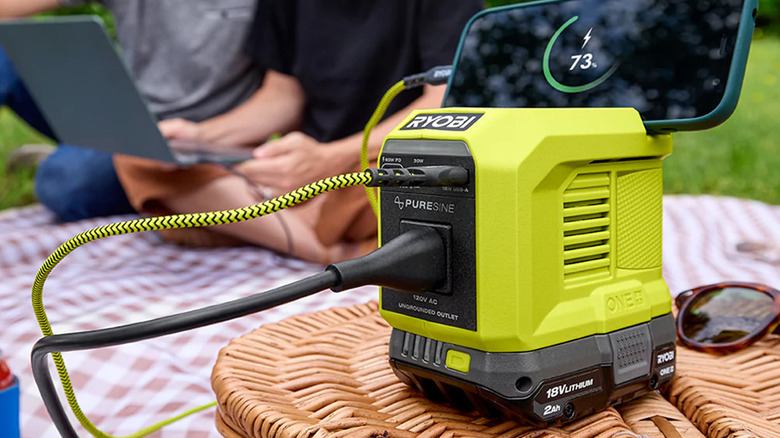 Ryobi 18V ONE+ 200W Power Source/Charger charging a phone and laptop.