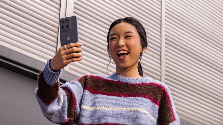Moto G Stylus (2026) held in hand of someone taking selfie while making a funny face