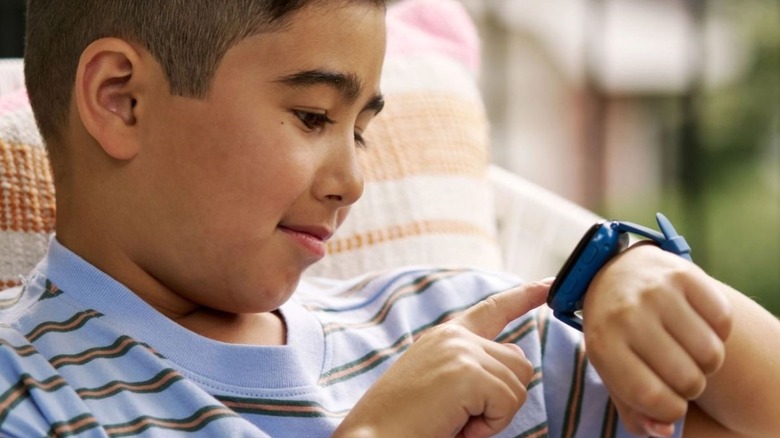 Boy using a Bark Watch on his wrist, a smart wearable for kids.