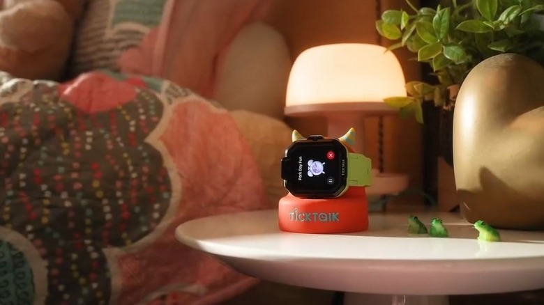 TickTalk 5 wearable for kids on the charging dock on a bedside table.