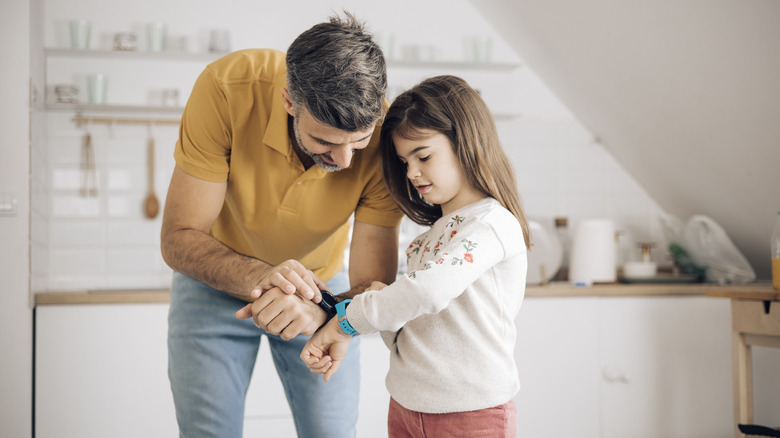 A father and daughter comparing their wearable devices.