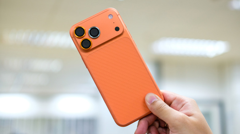 Close-up of a person holding the iPhone 17 Pro Max in Orange