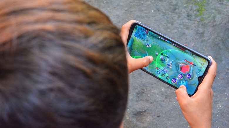 Close-up of a person playing a video game on a smartphone