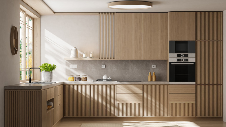 A modern kitchen with light wood cabinets and counters
