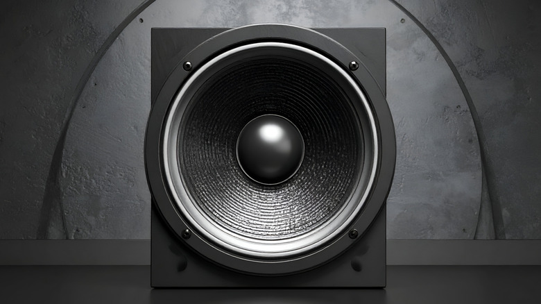 A subwoofer sitting in front of a concrete wall