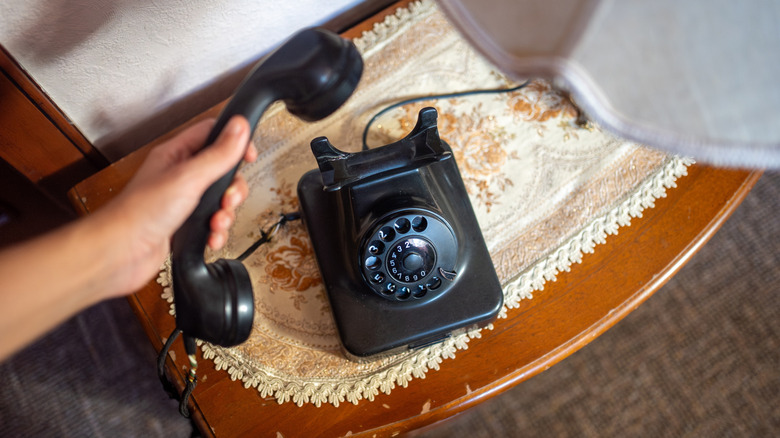 Hand holding vintage rotary telephone