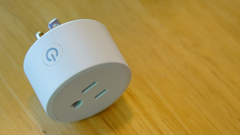 A Govee smart plug placed on a wooden surface.