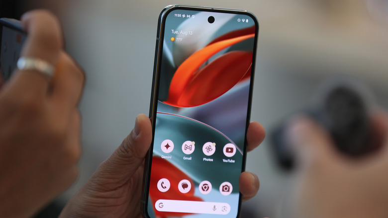 A person looks at the Google Pixel 9 phone during the Made By Google event