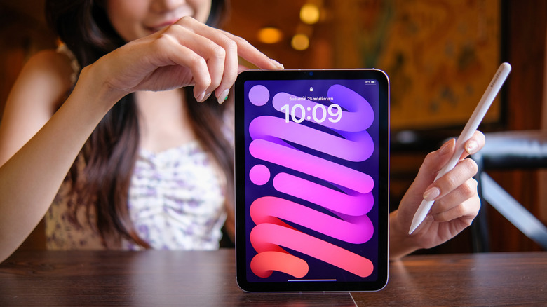 A person holding an iPad 7 and an Apple Pencil