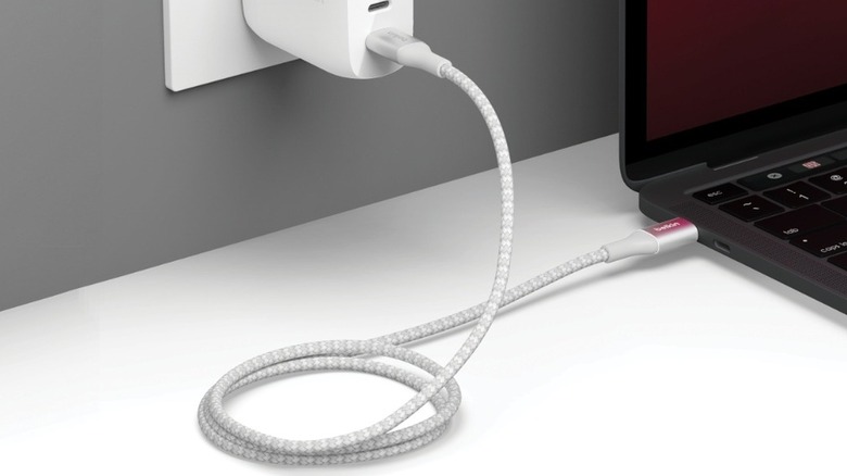 A Belkin USB-C cable charging a laptop via a wall adapter